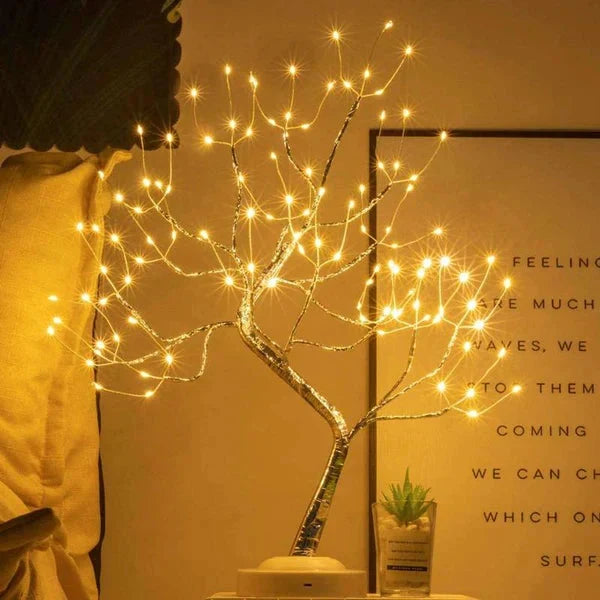 Lichterbaum mit vielen warmen Lichtern vor einer Wand mit Poster, daneben eine kleine Sukkulente 3