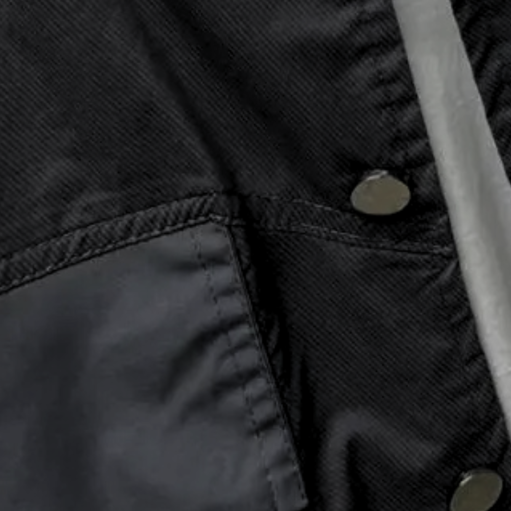 Schwarze Jacke aus Nylon mit Druckknöpfen und Tasche, modisch und wetterfest.
