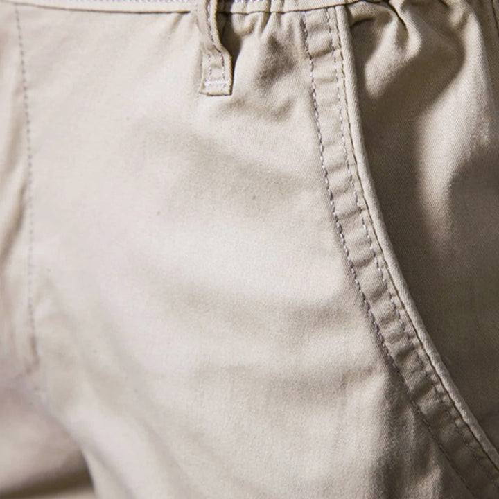 Nahaufnahme der Seitentasche an der beigen Shorts mit Ziernaht, Gürtelschlaufe und Bundansatz. 3