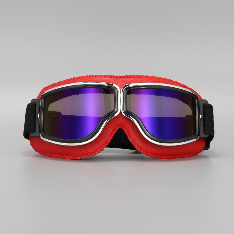 Frontansicht der Brille mit roter Polsterung und violett-blau verspiegelten Gläsern, Chromrahmen und schwarzem Band. 12