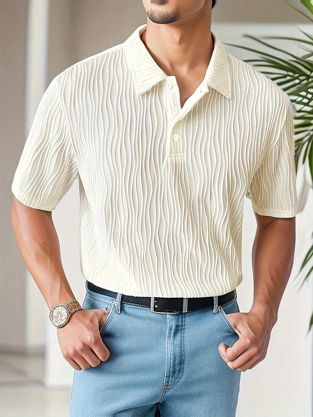 Mann trägt cremefarbenes Polohemd mit Struktur, blaue Jeans, goldene Uhr, modisch, elegant.