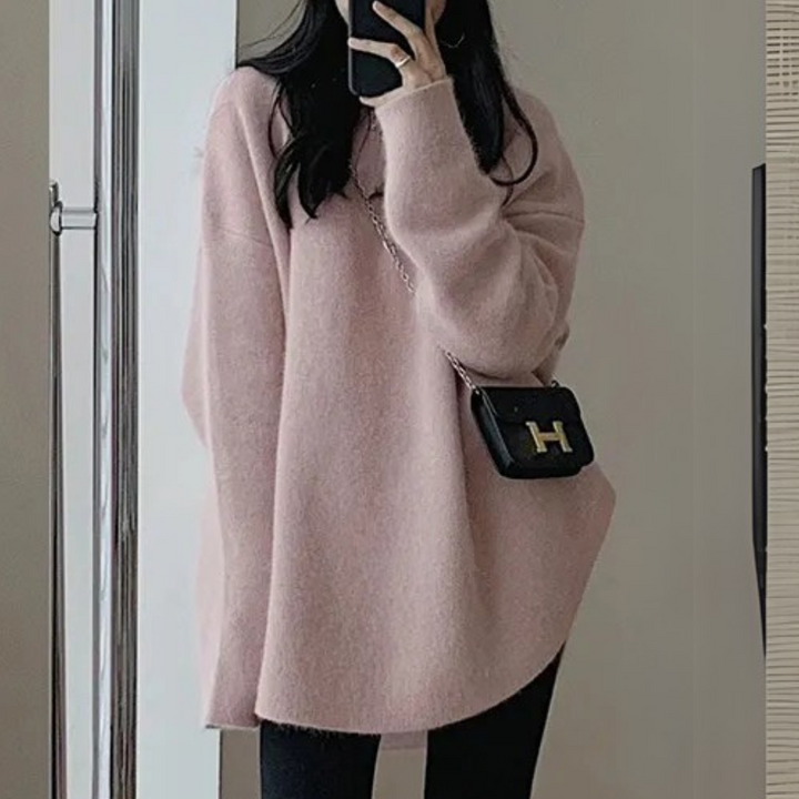 Frau in rosa Oversize-Pullover mit schwarzer Umhängetasche, modisch, lässig, Herbstmode.