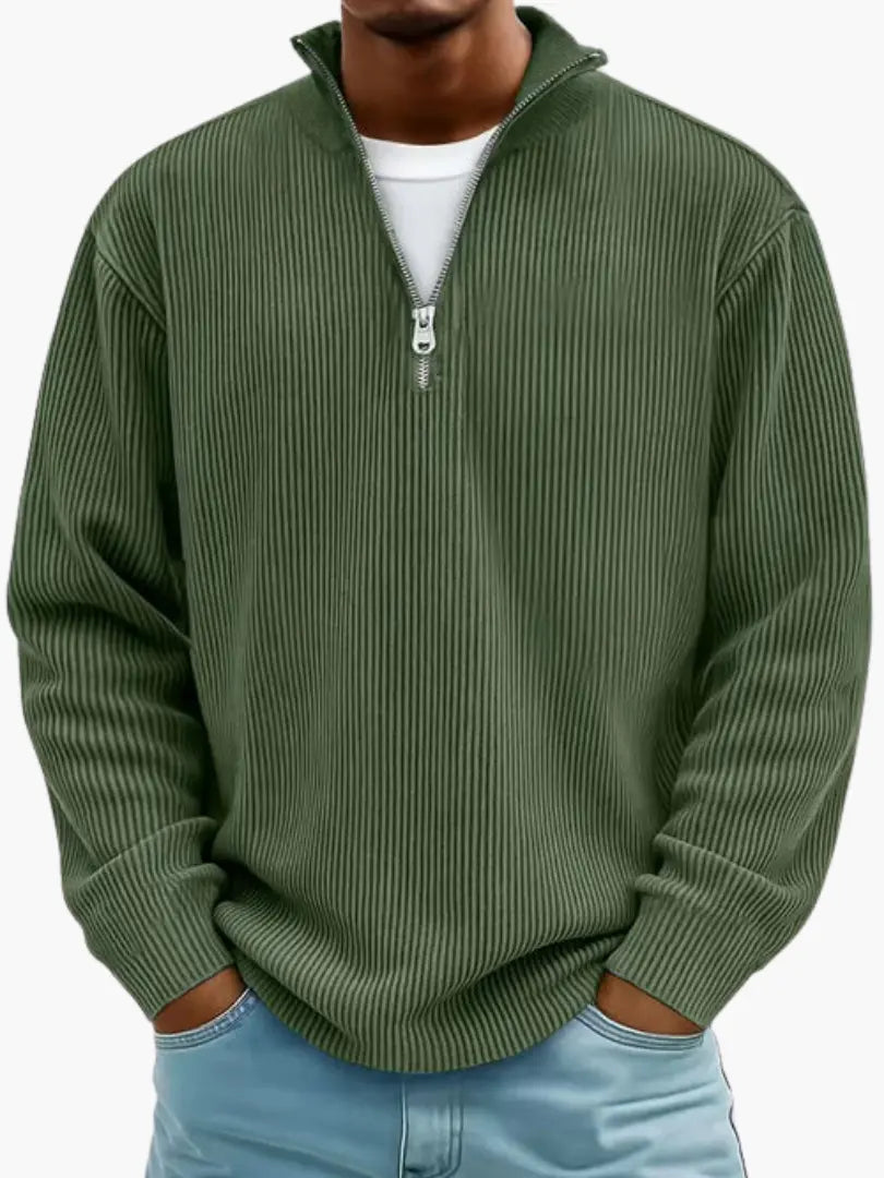 Gerippter Pullover in Olivgrün von vorn, mit silbernem Reißverschluss am Kragen und weißem Shirt darunter. 8
