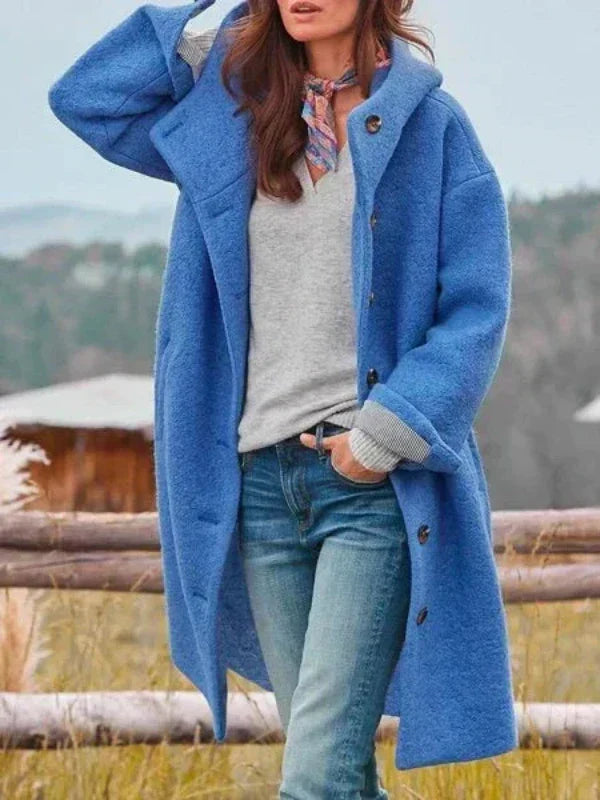 Langer Kapuzenmantel in Blau, offen getragen über grauem Pullover und Jeans, mit buntem Halstuch und umgeschlagenen Ärmeln. 4
