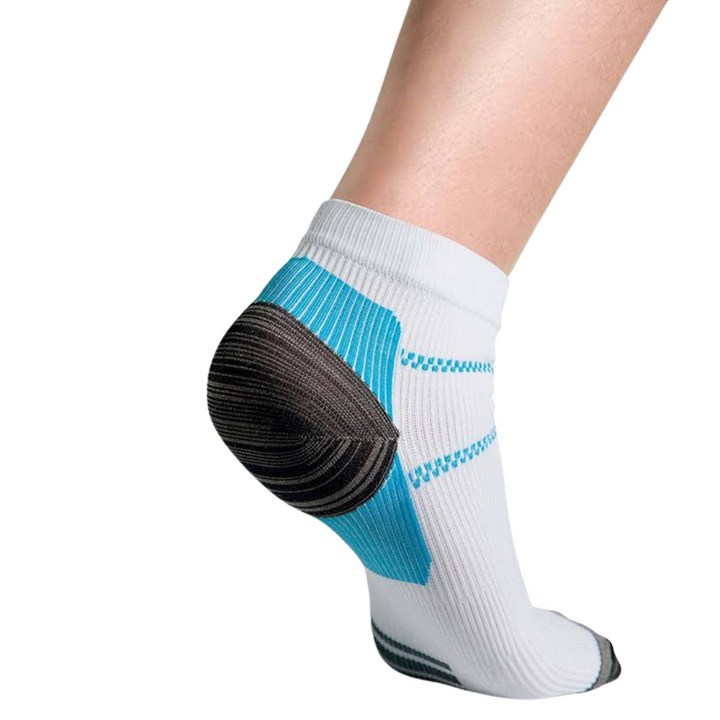 Rückansicht eines weißen Knöchelsocken am Fuß mit blauer Fersenpartie, dunkler Fersenkappe und blauen Zickzack-Streifen am Schaft. 1