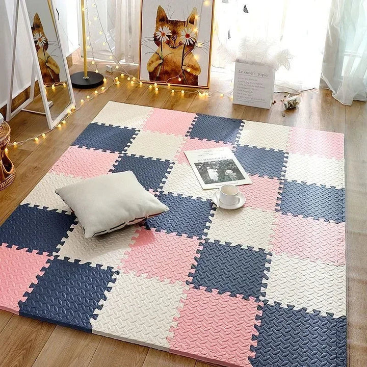 Puzzlematte in Rosa, Marineblau und Creme im Schachbrettmuster auf Holzboden, darauf ein Kissen, eine Zeitschrift und eine Tasse. 6