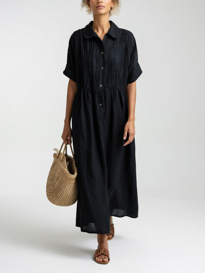 Das Hemdkleid in Schwarz von vorn, mit Rundkragen, gerafftem Taillenansatz und Strohtasche in der Hand. 7