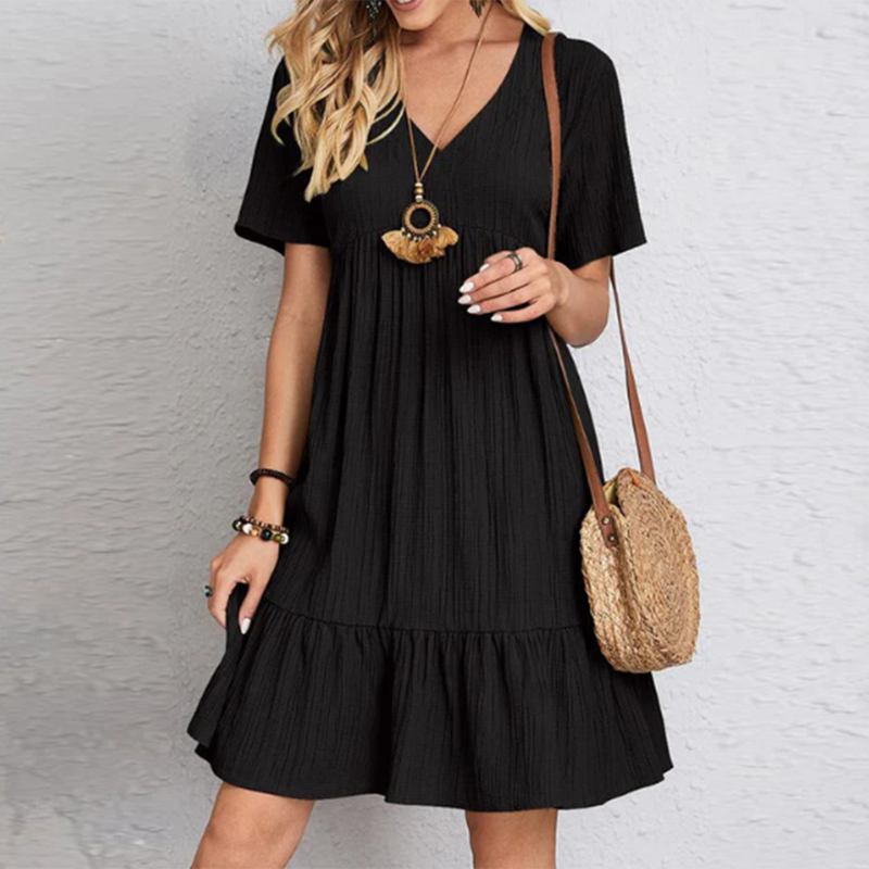 Frau in schwarzem Sommerkleid mit Strohtasche, modisches Outfit, Freizeitkleidung.