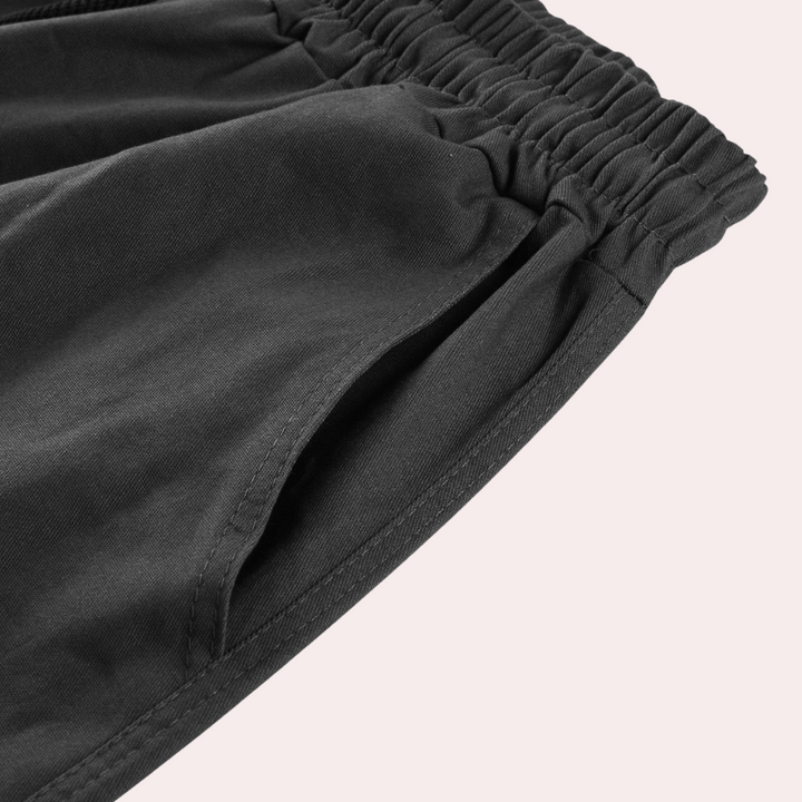 Schwarze Jogginghose mit elastischem Bund und Seitentasche, bequeme Sportbekleidung.