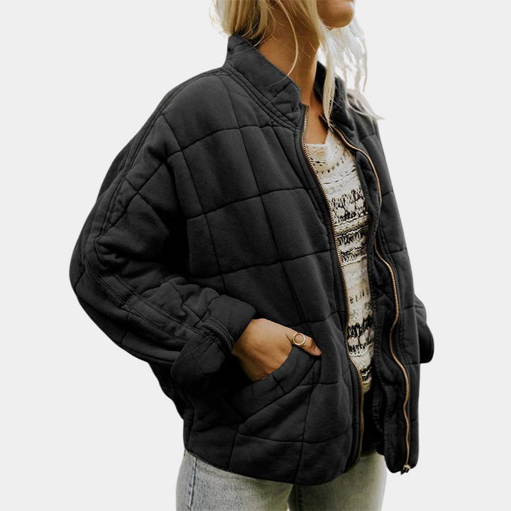 Frau in schwarzer Steppjacke, Reißverschluss, lässig, modisch, Herbstmode, Damenbekleidung.