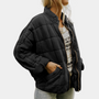 Frau in schwarzer Steppjacke, Reißverschluss, lässig, modisch, Herbstmode, Damenbekleidung.