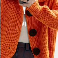 Orange Strickjacke mit großen Knöpfen, Damenmode, Herbstbekleidung, grob gestrickt.