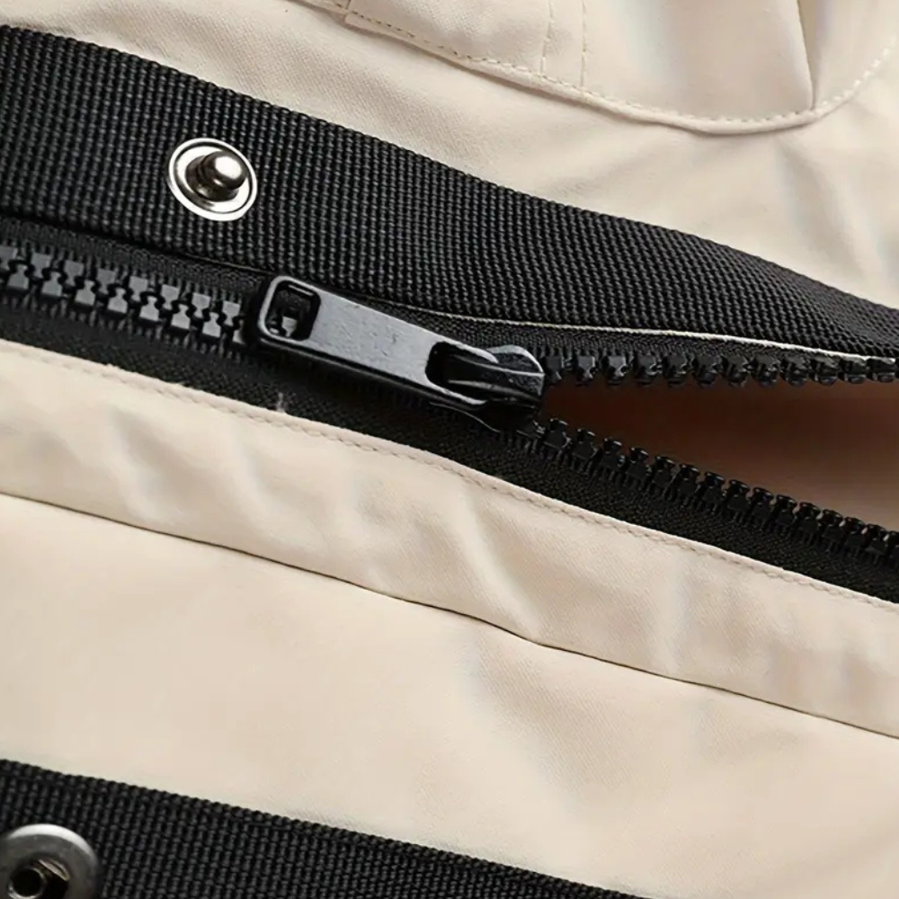 Beige Tasche mit schwarzem Reißverschluss, Nahaufnahme, strapazierfähiges Material, modisches Design.