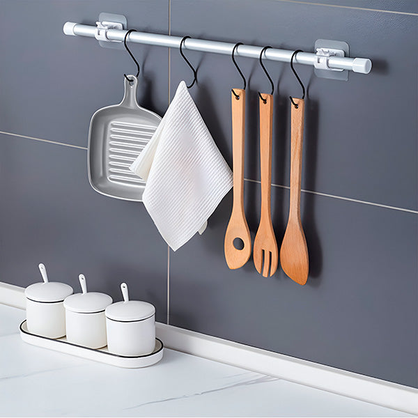 Küchenwand mit Stange an zwei Halterungen, an Haken hängen eine Grillpfanne, ein weißes Geschirrtuch und drei Holzbestecke. 6