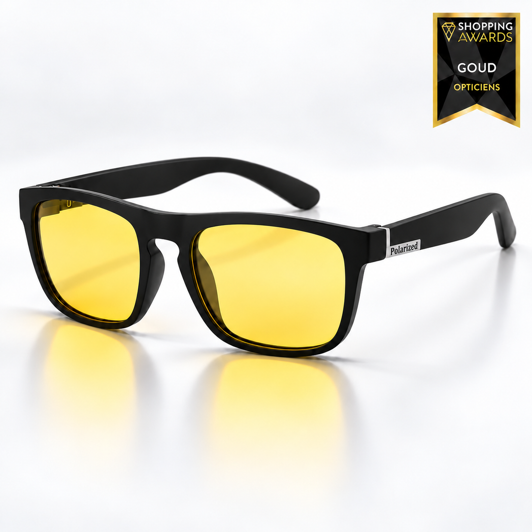 Nachtfahrbrille mit mattschwarzem eckigem Rahmen und gelben Gläsern, schräg von vorn mit Spiegelung auf hellem Untergrund. 9