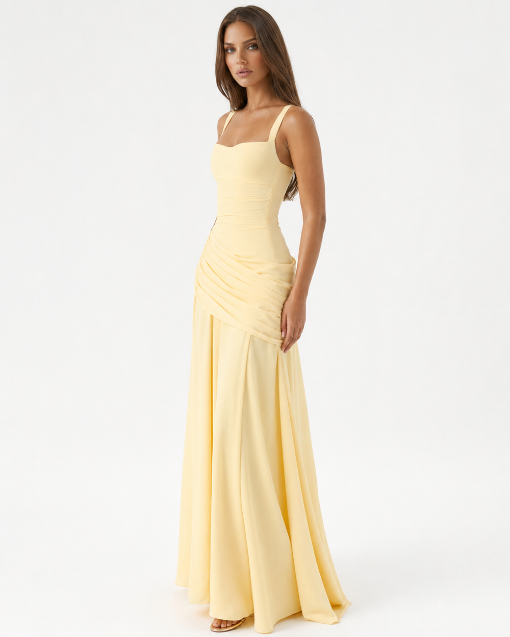 Hellgelbes Maxikleid in Dreiviertelansicht von der Seite, Model blickt zur Kamera, gerafftes Hüftteil und weit fließender Rock. 2