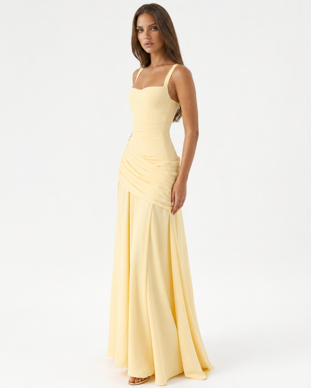 Hellgelbes Maxikleid in Dreiviertelansicht von der Seite, Model blickt zur Kamera, gerafftes Hüftteil und weit fließender Rock. 2