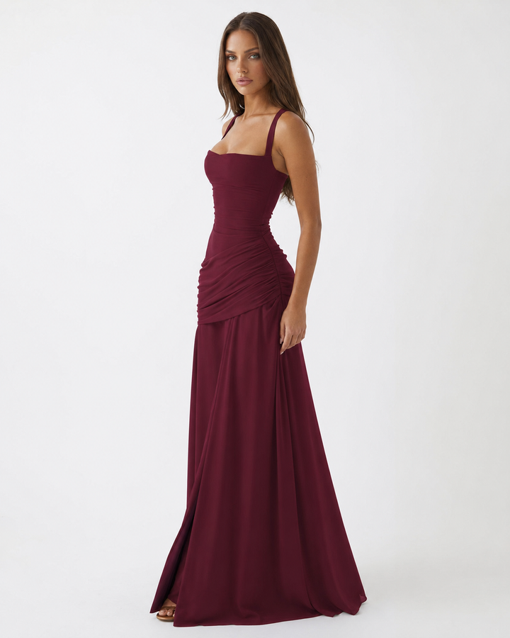 Weinrotes Maxikleid in Dreiviertelansicht, Model schaut zur Kamera, eng anliegendes Oberteil und fließender Rock. 18