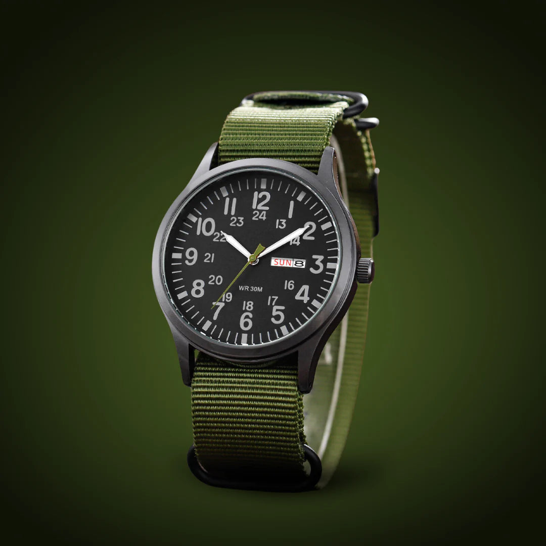 Schräg stehende Uhr mit grünem Stoffarmband und schwarzem Zifferblatt vor dunkelgrünem Hintergrund, Gehäuse und Krone seitlich sichtbar. 4