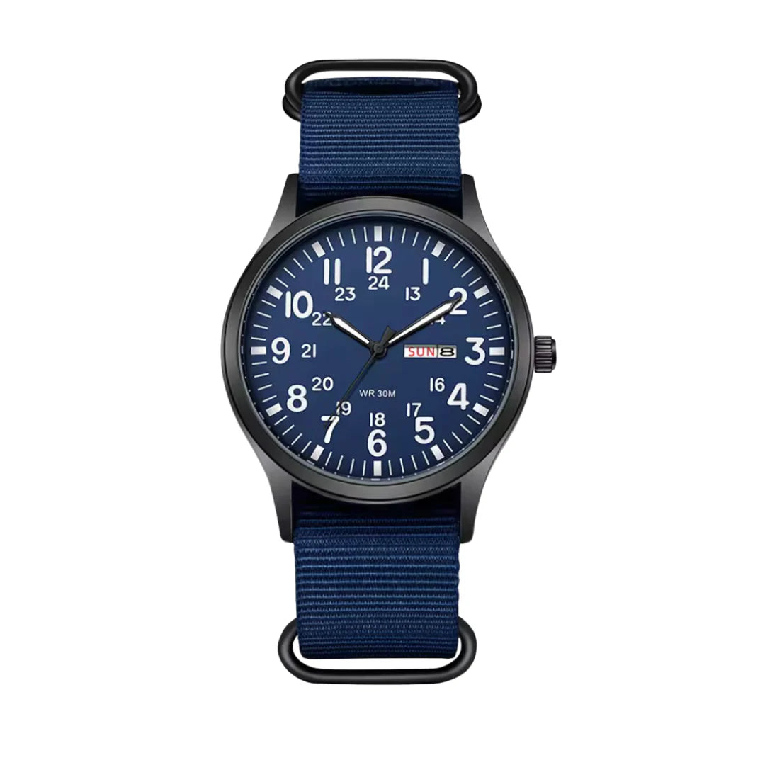 Variante mit blauem Zifferblatt, weißen Ziffern und dunkelblauem Stoffarmband, frontal vor weißem Hintergrund. 6