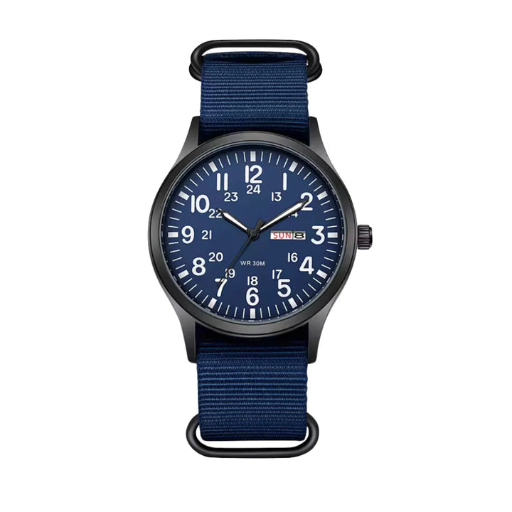 Variante mit blauem Zifferblatt, weißen Ziffern und dunkelblauem Stoffarmband, frontal vor weißem Hintergrund. 6
