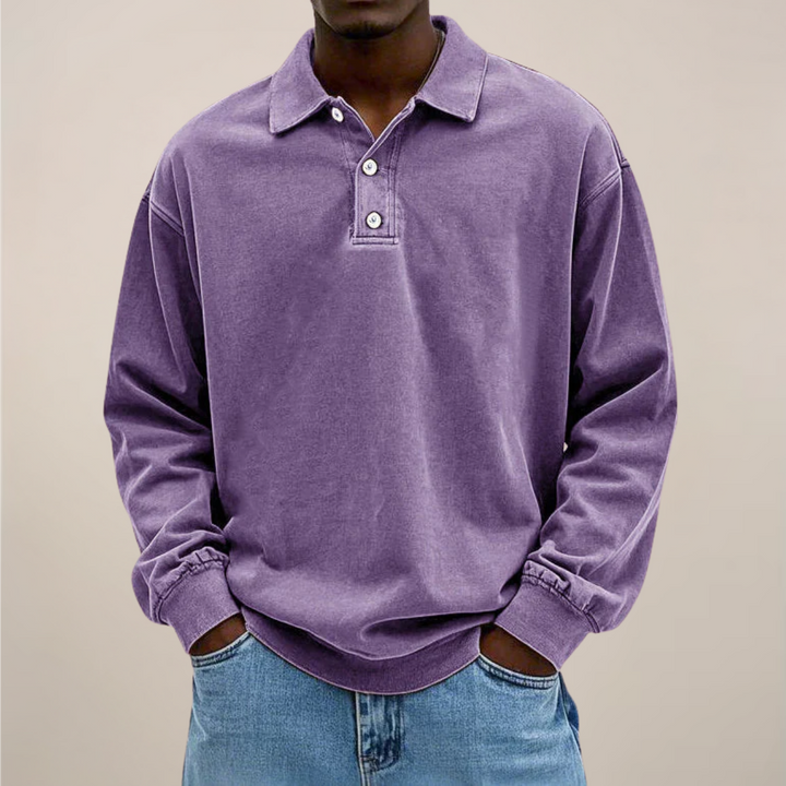 Das Langarm-Poloshirt in Violett an einem Model, mit Kragen, drei Knöpfen und gerippten Ärmelbündchen. 4