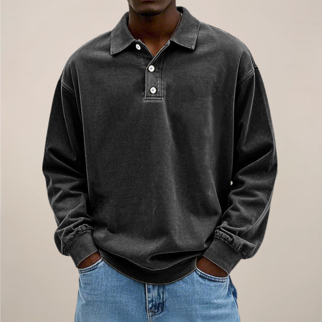 Model trägt das Poloshirt in Schwarz mit drei Knöpfen am Kragen und gerippten Bündchen, dazu Jeans. 8