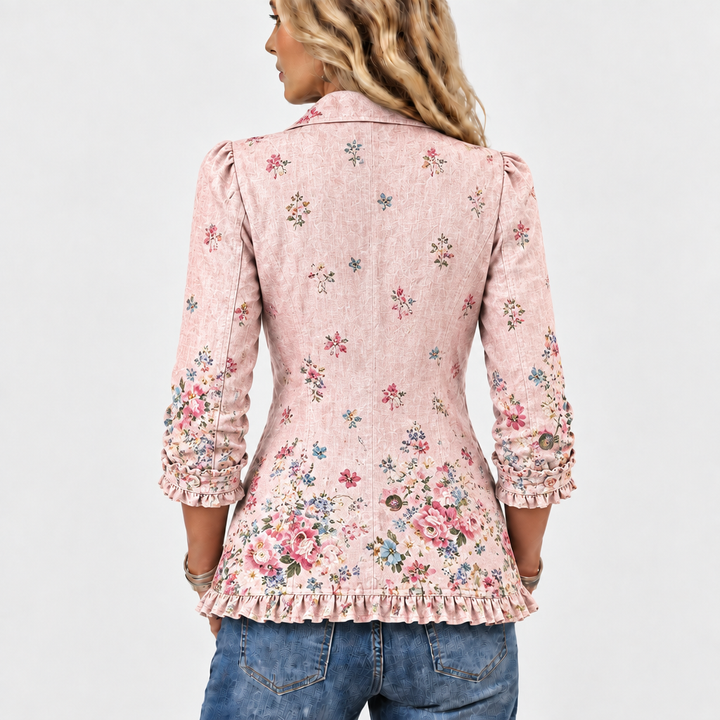 Rückenansicht der rosa Jacke mit verstreuten Blumenmotiven, dichterem Blumenmuster am unteren Rücken und Rüschensaum. 5