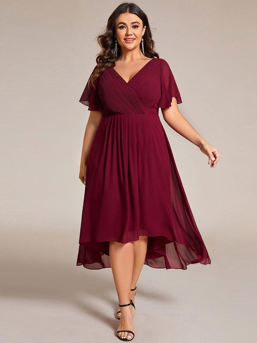 Plus-Size-Model im weinroten Kleid mit V-Ausschnitt, Flatterärmeln und Hoch-Tief-Saum, Vorderansicht mit langen Ohrringen. 49
