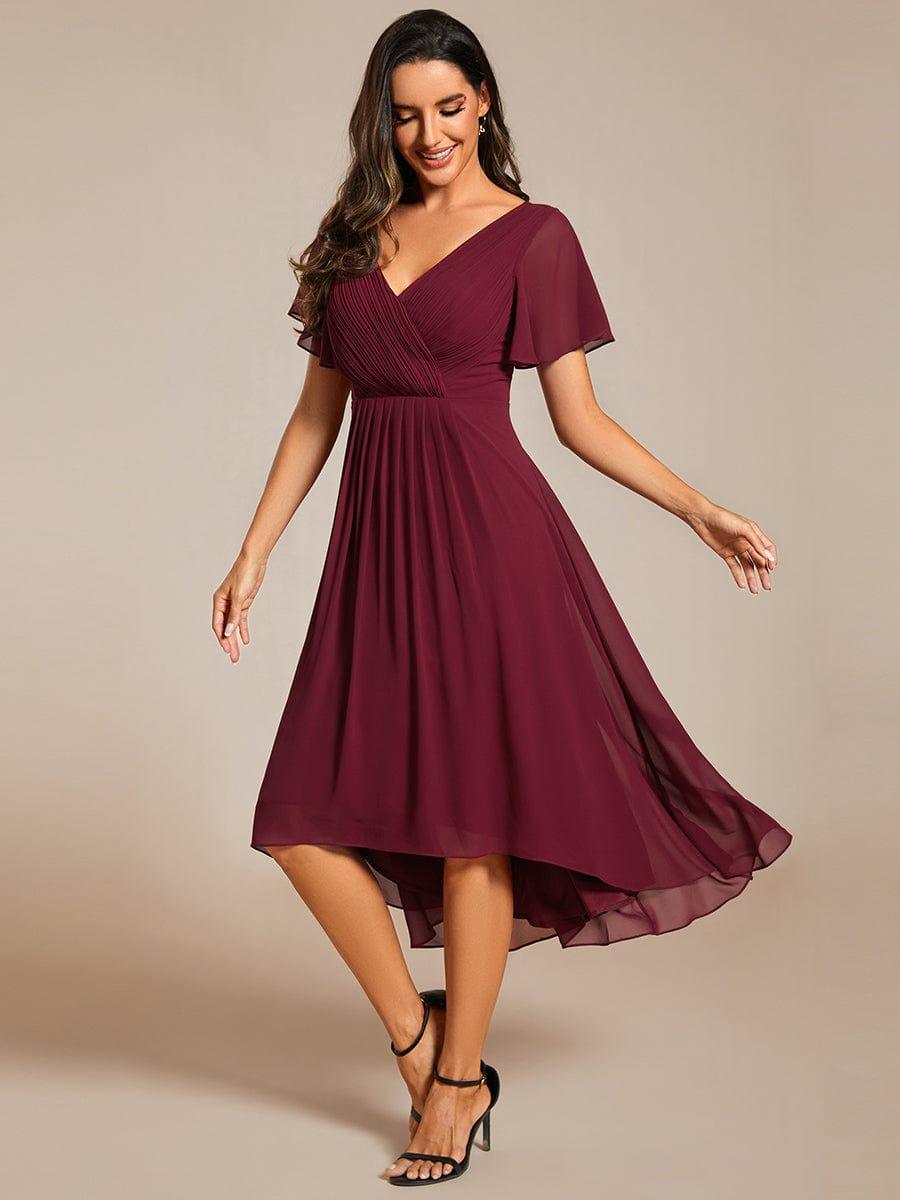 Weinrotes Chiffonkleid mit Hoch-Tief-Saum am schlanken Model, leicht drehend in Bewegung, schwarze Riemchensandalen. 47