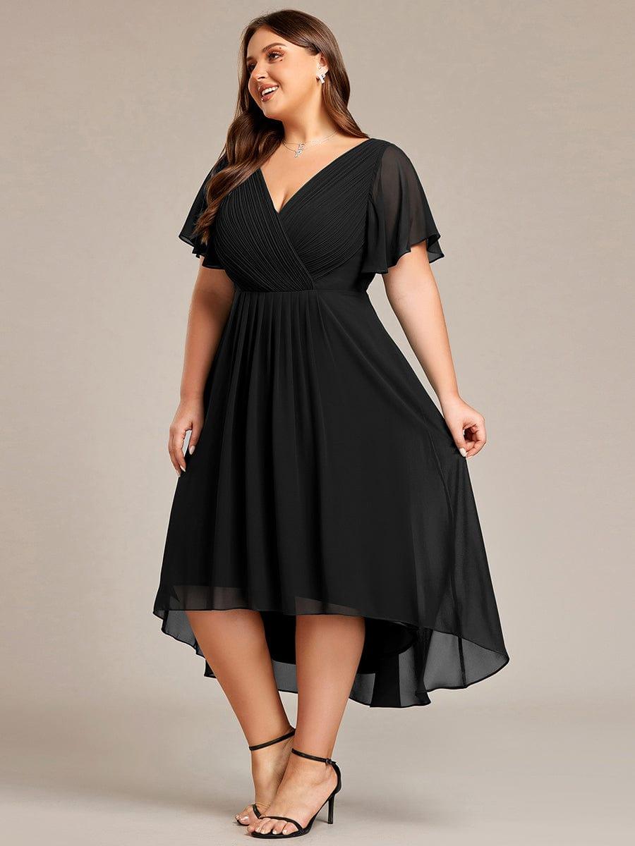 Curvy Model im schwarzen Chiffonkleid in Seitenansicht, hält den Rock leicht seitlich, der Saum fällt hinten deutlich länger. 29