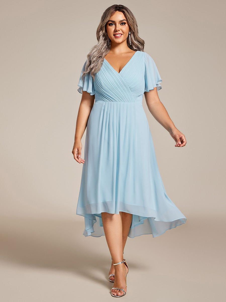 Curvy Model in hellblauem Chiffonkleid mit plissiertem V-Ausschnitt, im Gehen fotografiert, mit silbernen Sandaletten. 89