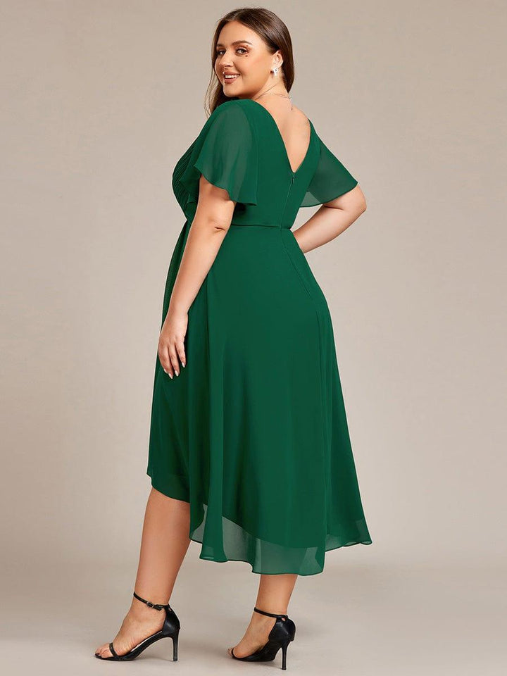 Dunkelgrünes Chiffonkleid von hinten an einem Curvy Model, über die Schulter lächelnd, mit V-Rückenausschnitt, Reißverschluss und halbtransparenten Ärmeln. 37
