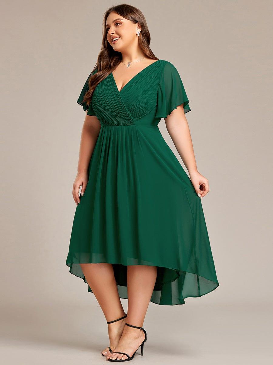 Curvy Model im dunkelgrünen Kleid in Seitenansicht, hält den Rock leicht, der Chiffonsaum fällt hinten länger als vorne. 39