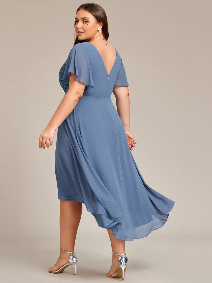 Rückansicht des staubblauen Kleids am Plus-Size-Model mit tiefem V-Rückenausschnitt, Reißverschluss und fließendem Chiffonsaum. 42