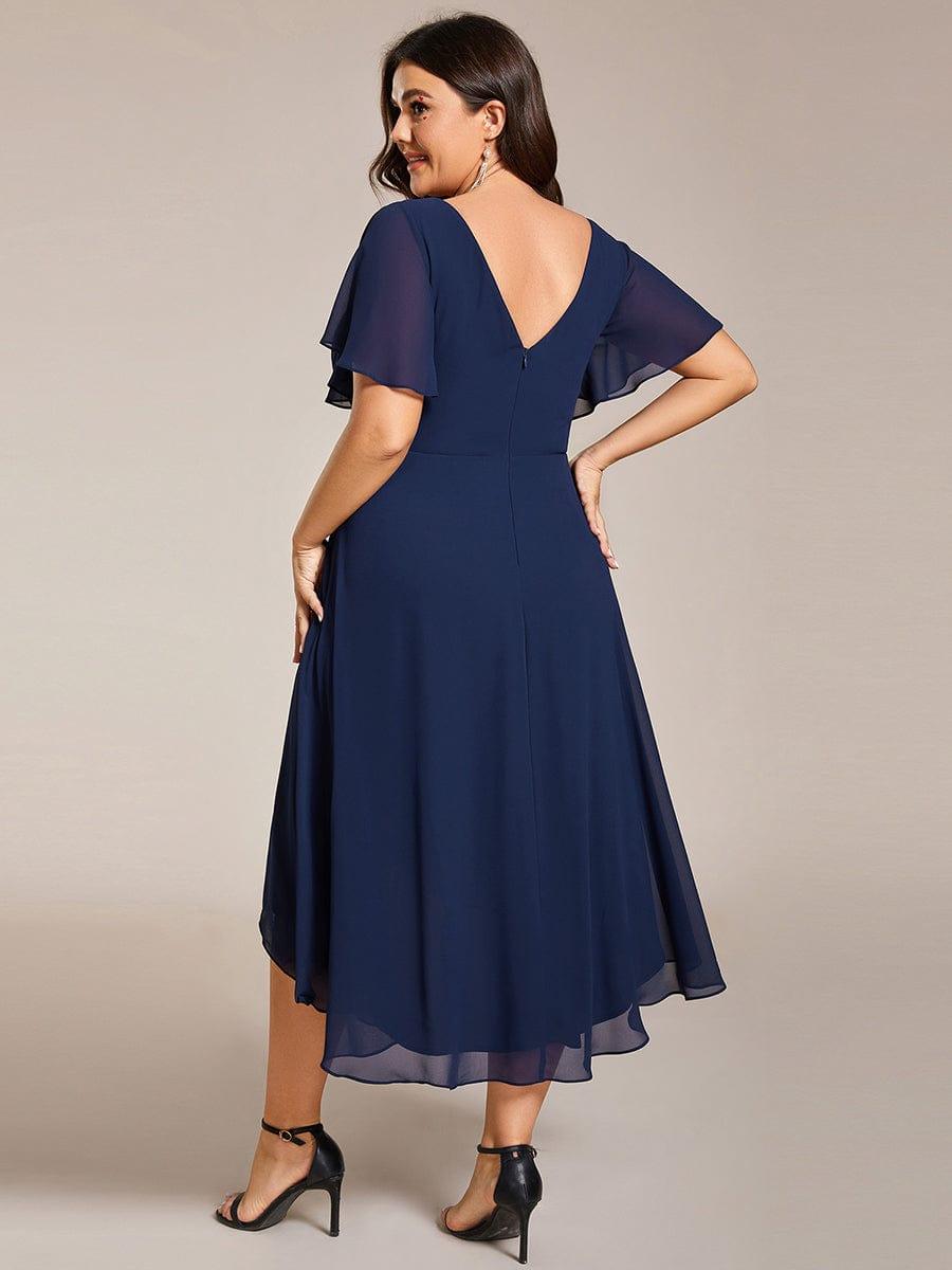 Rückansicht des marineblauen Kleids am Plus-Size-Model mit tiefem V-Rückenausschnitt, Reißverschluss und gestuftem Chiffonsaum. 56