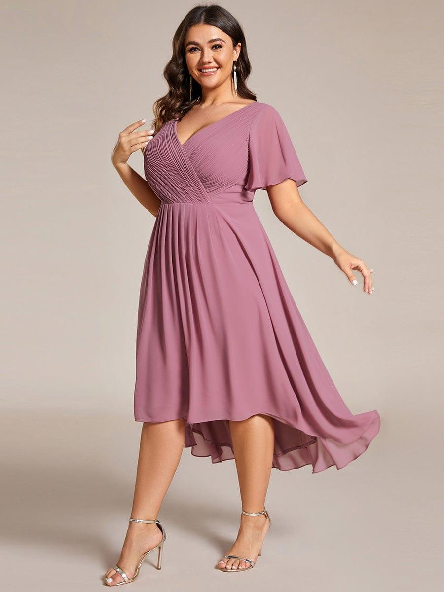 Seitlich gedrehte Ansicht am Curvy-Model: der mauvefarbene Chiffonrock schwingt mit, Wickeloberteil und Flatterärmel sind gut zu erkennen. 67