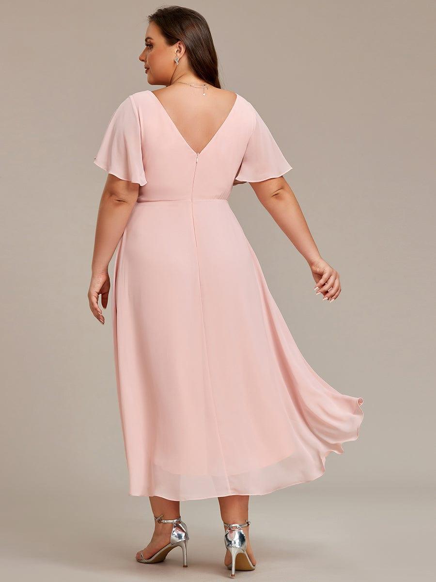 Rückansicht des rosafarbenen Chiffonkleids an einem Curvy Model, tiefer V-Rückenausschnitt mit Reißverschluss und längerem Saum hinten. 32