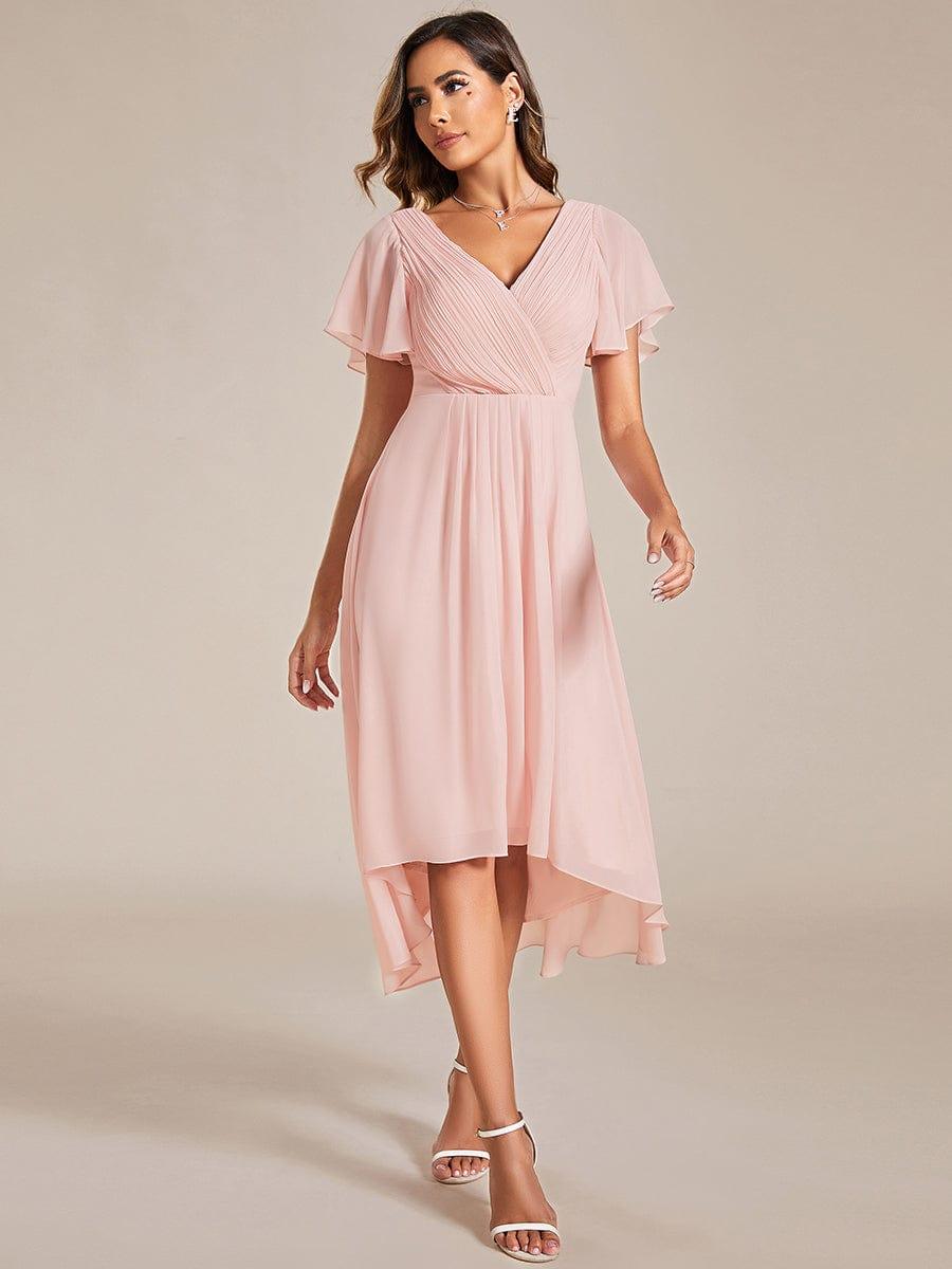 Rosafarbenes Kleid im Gehen fotografiert, Model blickt zur Seite, der Chiffonrock schwingt mit und zeigt den asymmetrischen Saum. 20