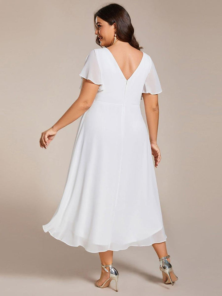 Rückansicht des weißen Kleids am Curvy-Model: V-Rückenausschnitt mit Reißverschluss, Flatterärmel und fließender, hinten länger fallender Rock. 74