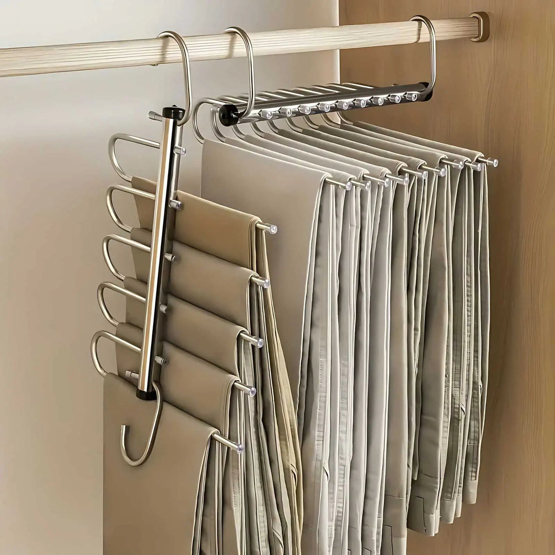 Zwei Edelstahl-Hosenbügel an der Kleiderstange, einer zur Seite aufgeklappt mit fünf Hosen, der andere zusammengeschoben mit vielen Hosen. 1