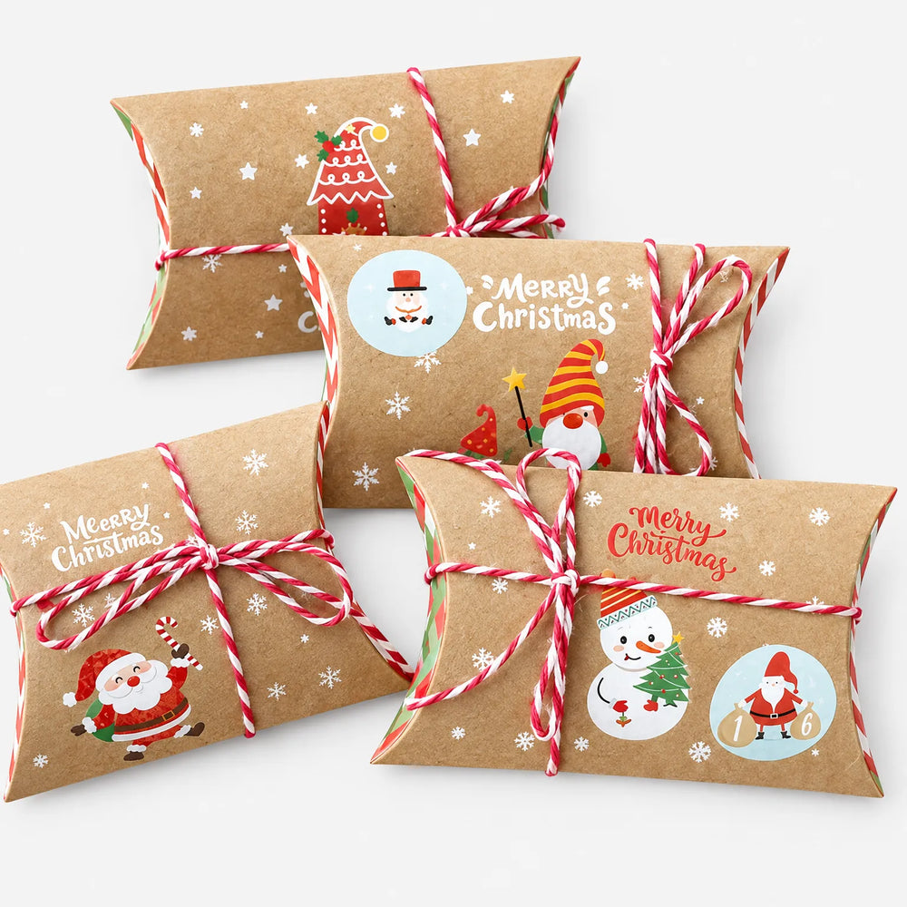 Vier Kissenboxen aus Kraftpapier mit rot-weißer Schnur und verschiedenen Weihnachtsmotiven wie Weihnachtsmann, Schneemann und Wichtel vor hellem Hintergrund. 2