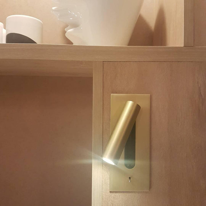 Goldfarbene Wandleuchte in Holzregal eingebaut, der Lichtkegel strahlt nach links 32