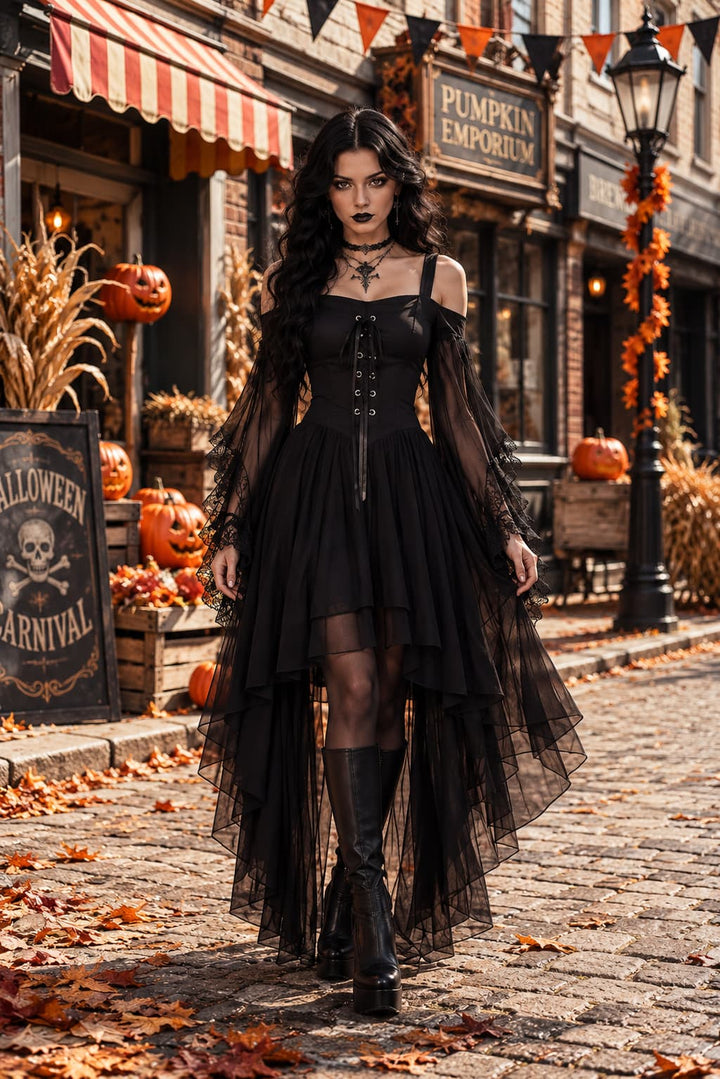 Model im schwarzen Kleid mit Schnürung und Spitzenärmeln auf herbstlicher Kopfsteinpflasterstraße mit Kürbissen 1