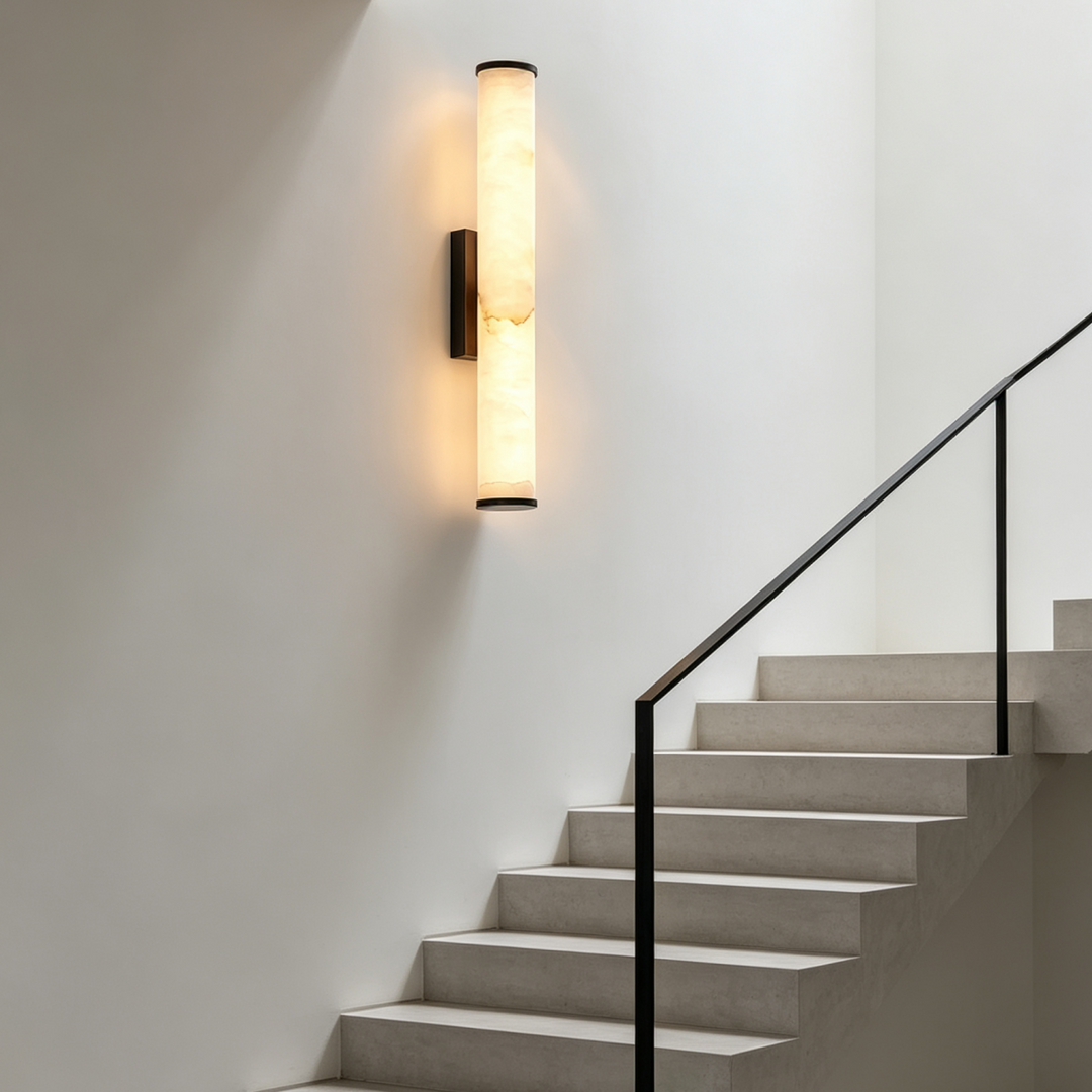 Leuchtende Marmor-Wandleuchte mit dunklen Enden an einer weißen Wand in einem Treppenhaus neben Betontreppe und schwarzem Geländer. 7
