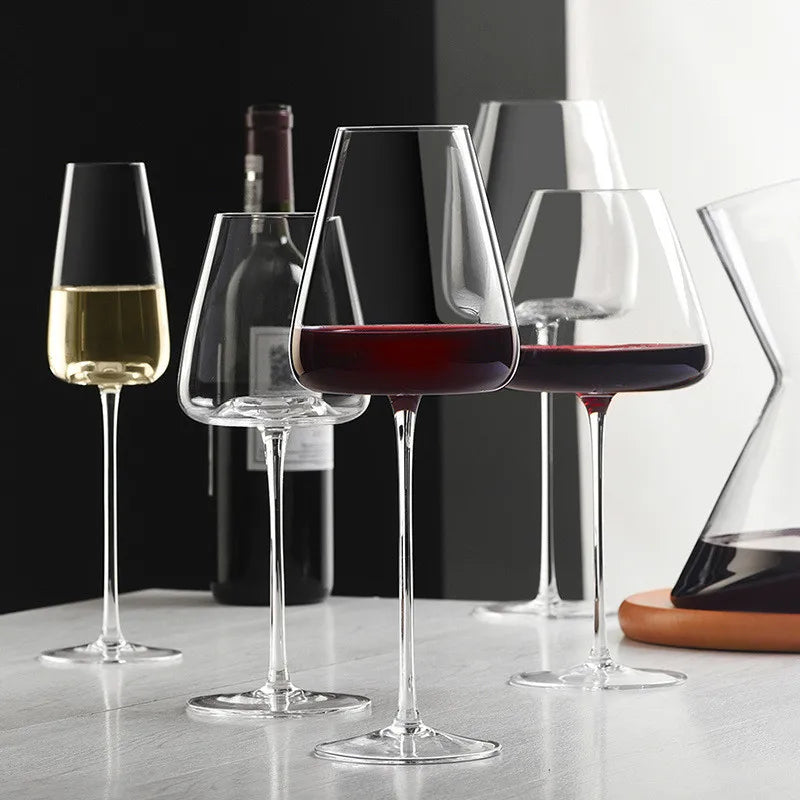 Mehrere Gläser mit Rot- und Weißwein, eine Weinflasche und eine Karaffe auf hellem Tisch 5