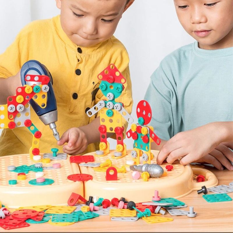 Zwei Kinder bauen gemeinsam bunte Figuren auf der Lochplatte, eines hält dabei den blauen Spielzeugbohrer an eine Schraube. 3