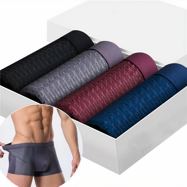 Vier zusammengerollte Boxershorts in Schwarz, Grau, Weinrot und Blau in weißer Box, dazu ein Model im Ausschnitt 1
