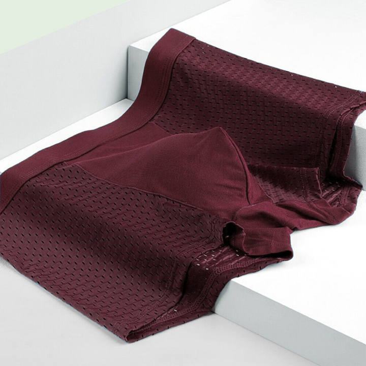 Weinrote Boxershorts flach auf weißen Stufen liegend, mit Lochgewebe an den Seiten und glattem Mittelteil 6