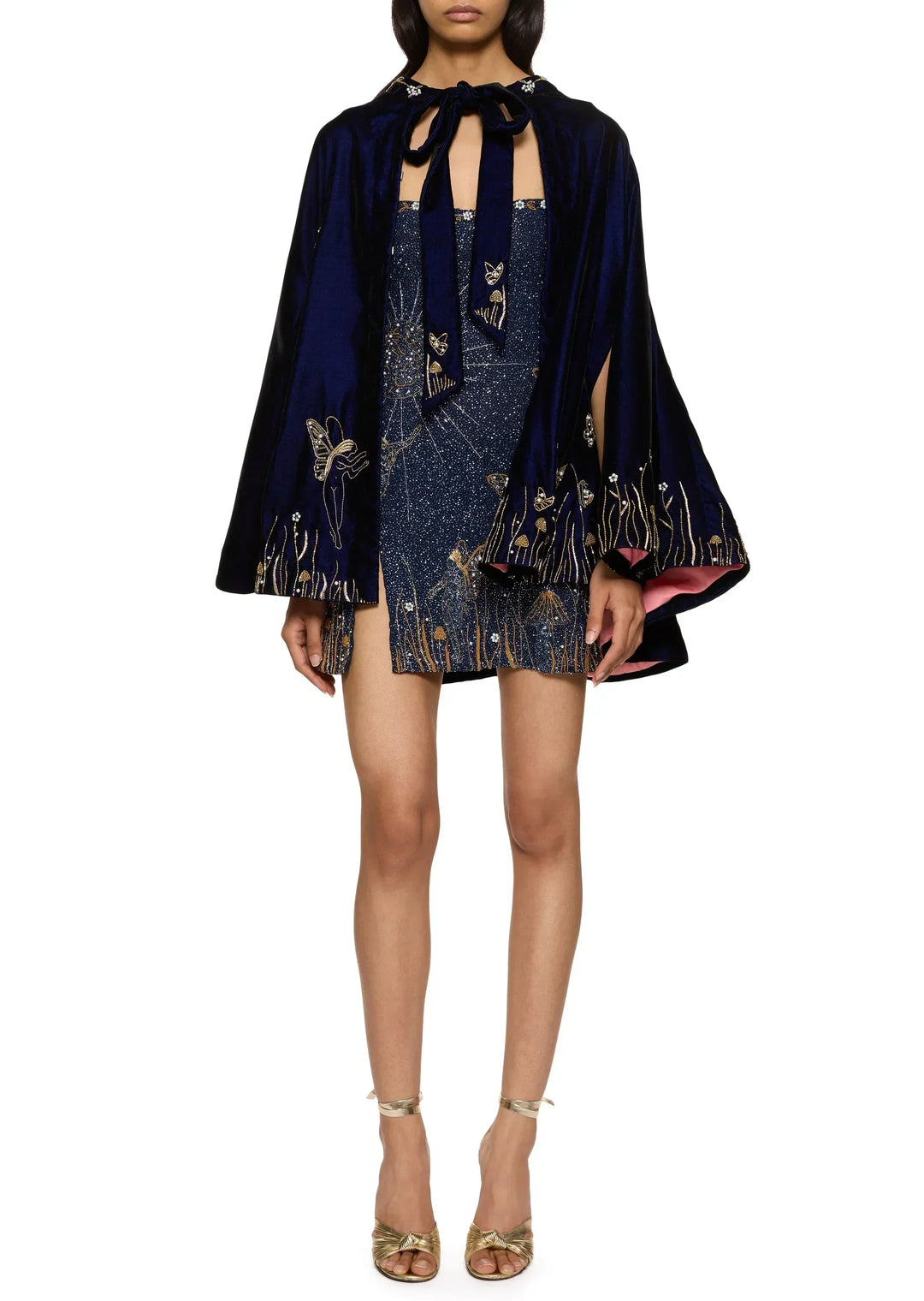 Model trägt das Minikleid unter einem dunkelblauen, bestickten Samtcape mit Schleife und rosa Futter 9